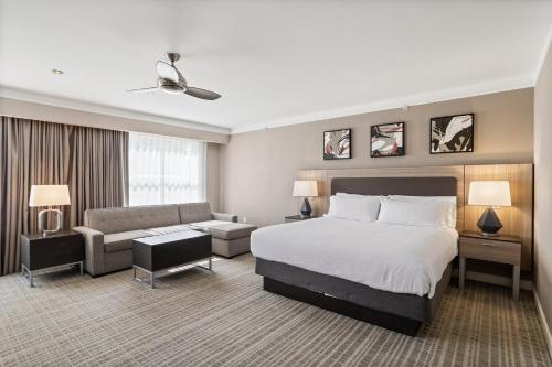 a hotel room with a bed and a couch at Holiday Inn Baton Rouge College Drive I-10 by IHG in Baton Rouge