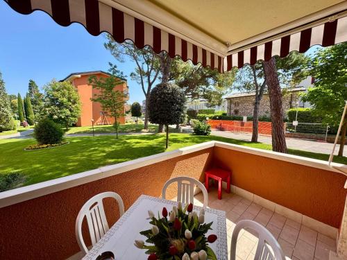 a balcony with a table and chairs and a view of a yard at Premium Apartments Peschiera in Peschiera del Garda