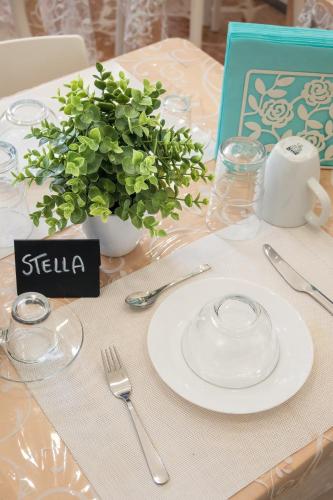 a table with a white plate and a plant on it at Ciccio Rooms and breakfast - Self check-in in Palermo