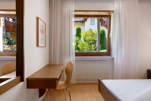 a bedroom with a desk and a bed and a window at Hofanger in Lagundo