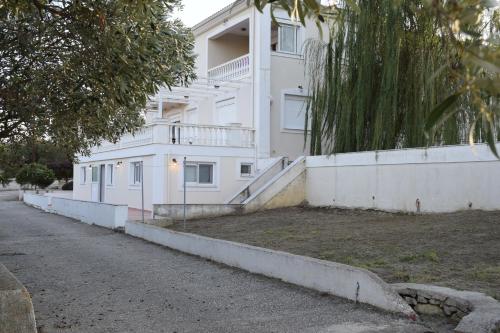 a white apartment building with a street in front of it at Traditional apartment in nature in Kouvaláta