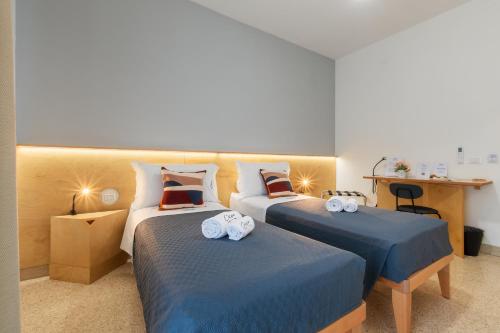 a bedroom with two beds with blue sheets at Ciccio Rooms and breakfast - Self check-in in Palermo