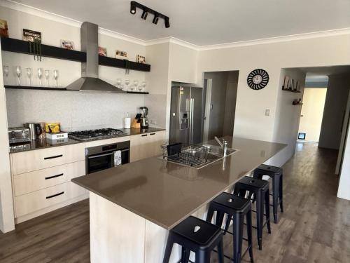 a kitchen with a large island with bar stools at Garrison Cottage in The Vines