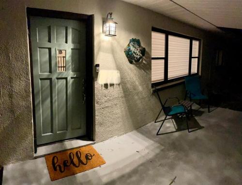 an empty room with a green door and a chair at Clearwater Hideaway w Huge Lap POOL 7 min to BEACH in Clearwater