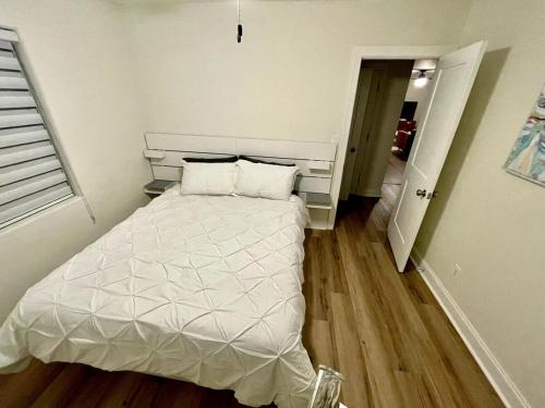 a bedroom with a white bed in a room at Clearwater Hideaway w Huge Lap POOL 7 min to BEACH in Clearwater