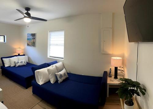 a living room with a blue couch and a table at Clearwater Hideaway w Huge Lap POOL 7 min to BEACH in Clearwater