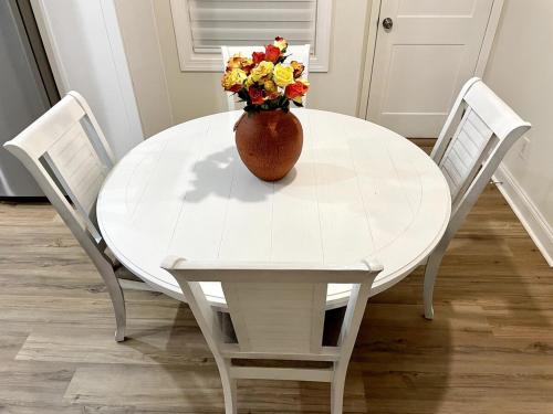 a white table with a vase of flowers on it at Clearwater Hideaway w Huge Lap POOL 7 min to BEACH in Clearwater