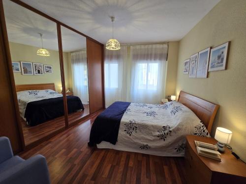 サンタンデールにあるAPARTAMENTO FAMILIAR Centrico Grupo RH-72のベッドと大きな鏡のある寝室