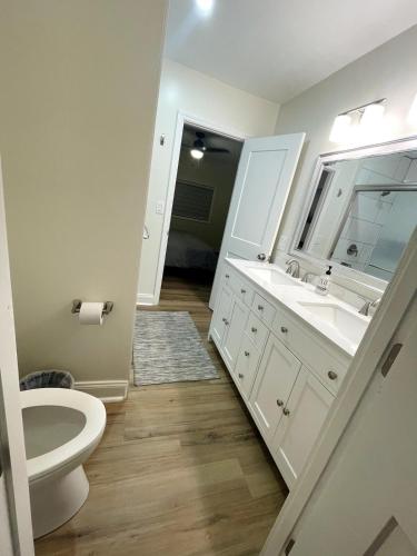 a white bathroom with a sink and a toilet at Clearwater Hideaway w Huge Lap POOL 7 min to BEACH in Clearwater