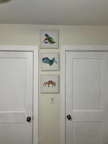 two white doors in a room with pictures on the wall at Clearwater Hideaway w Huge Lap POOL 7 min to BEACH in Clearwater