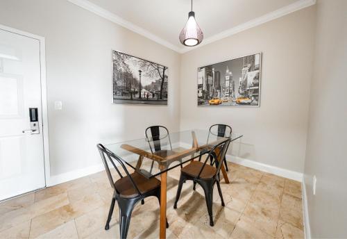 a dining room with a glass table and chairs at Nuvo Suites Hotel - Miami Doral in Miami