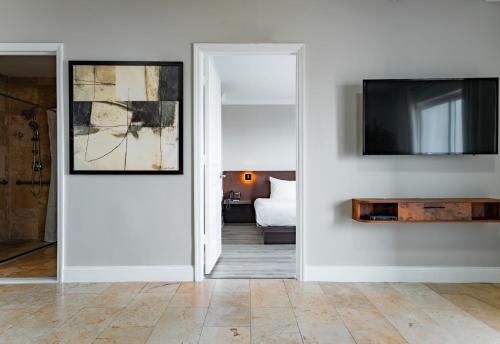 a living room with a television and a white wall at Nuvo Suites Hotel - Miami Doral in Miami