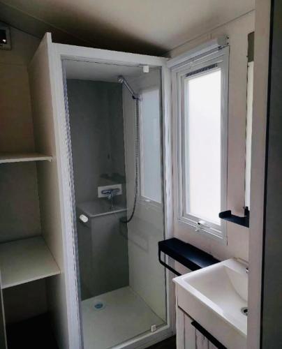 une salle de bain avec une douche et un lavabo et une fenêtre dans l'établissement Mobilhome 6 places Domaine de Chaussy, à Lagorce