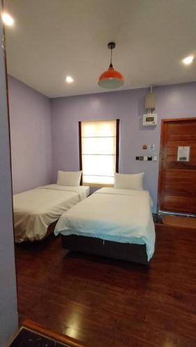 a bedroom with two beds and a window at โอรีสอร์ต Oresort in Ban Chua Phloeng