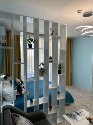 a living room with a book shelf with potted plants at Дрийм 2 Мечта 2 in Sunny Beach