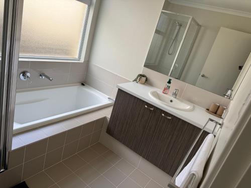 a bathroom with a tub and a sink and a bath tub at Garrison Cottage in The Vines