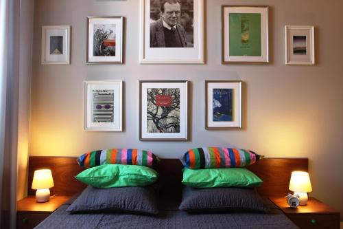 a bedroom with two pillows and pictures on the wall at Apartamenty Czapskich in Kraków