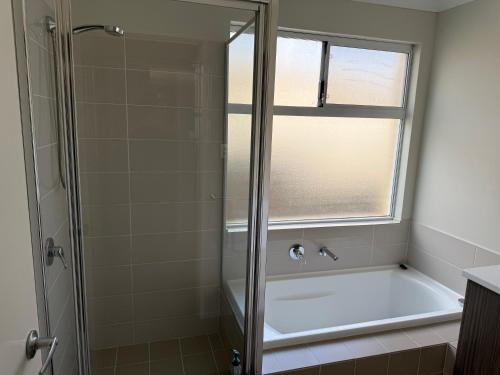 a bathroom with a bath tub and a window at Garrison Cottage in The Vines