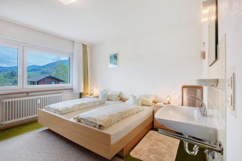 a bedroom with a bed and a sink and a window at Ferienwohnung Karrach in Bernau im Schwarzwald