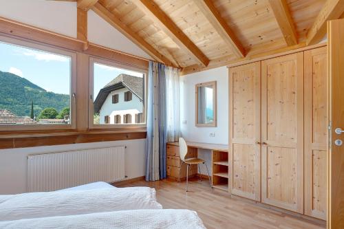 a bedroom with a bed and a desk and a window at Hofanger in Lagundo