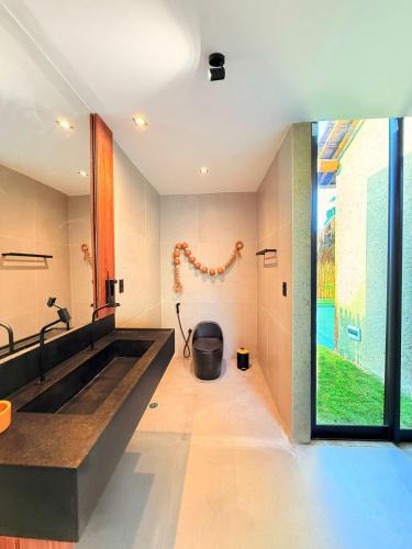 a bathroom with a large sink and a large window at Naca Boutique Hotel in Pôrto de Pedras