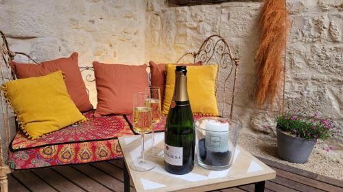 - une bouteille de vin sur une table à côté d'un canapé dans l'établissement Les Coups de Coeur du Quercy, à Montpezat-de-Quercy