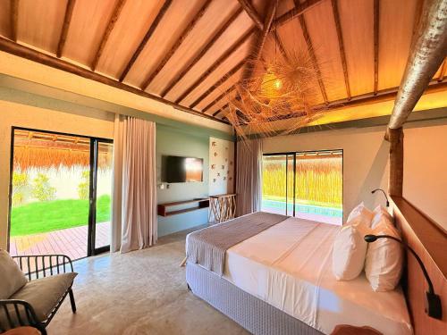 ein Schlafzimmer mit einem Bett und einem großen Fenster in der Unterkunft Naca Boutique Hotel in Pôrto de Pedras