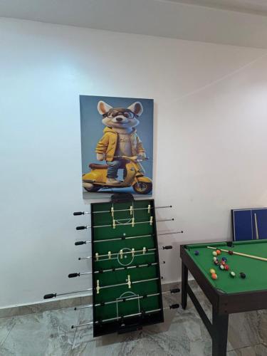 a painting of a cat on a motorcycle next to a pool table at 2bedroom luxury apartment in Lekki