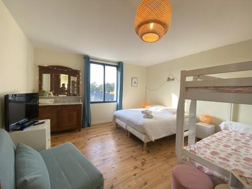 ein Schlafzimmer mit einem Etagenbett und einem TV in der Unterkunft Villa La Foliotte in Saint-Pair-sur-Mer