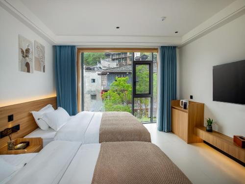 Postel nebo postele na pokoji v ubytování Fenghuang County Jiduo Intelligent Hotel