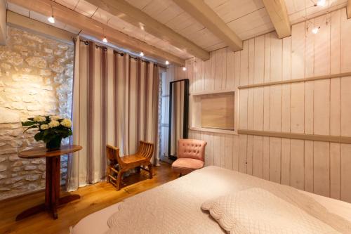 a bedroom with a bed and a desk and a chair at Château de Mazières in Tendu
