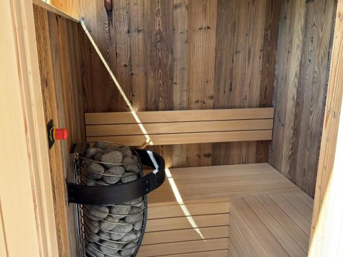 a sauna with a basket of rocks in it at Das Goldjuwel - Luxury Apartments with private Spa in Goldegg