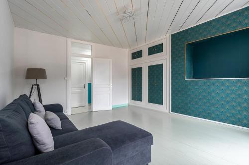 a living room with a couch and a flat screen tv at Maison Raphaëla, Élégance et Lumière au Cœur des Monts du Bugey in Tenay