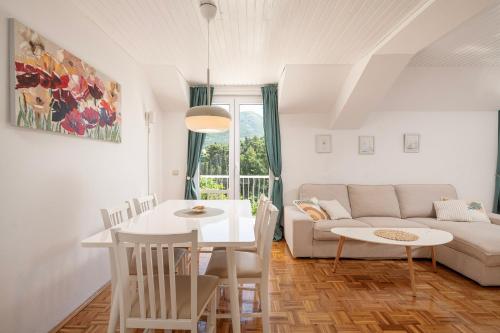 a living room with a white table and a couch at Apartments Maria in Cavtat