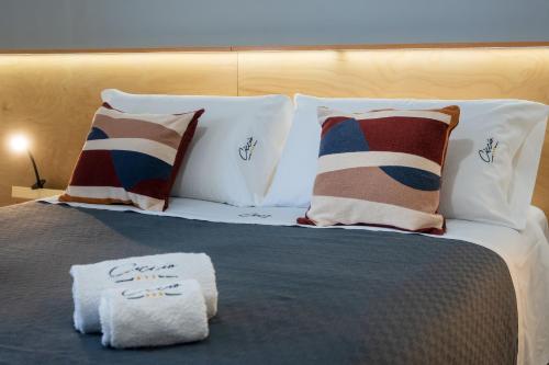 a bed with pillows and towels on top of it at Ciccio Rooms and breakfast - Self check-in in Palermo