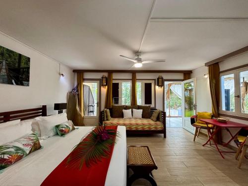 a living room with a bed and a couch at Serenity - Evasion exotique avec Jardin et Piscine in Saint-François