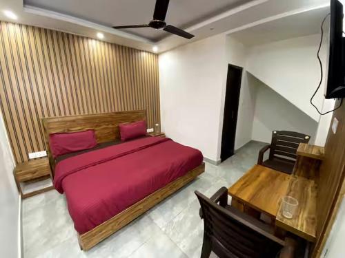a bedroom with a red bed and a desk at Nona shona chill point homestay and cafe in Mussoorie
