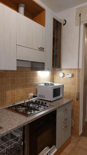 a kitchen with a stove and a microwave at Casa vacanza PASsaggio in Como
