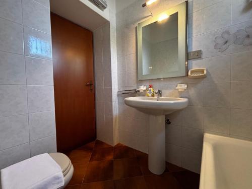 a bathroom with a sink and a toilet and a mirror at Casa Leima - Larihome A83 in Gera Lario