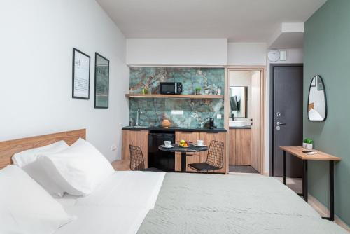 a bedroom with a bed and a desk in a room at Makas Beachfront Suites Hersonissos Center in Hersonissos