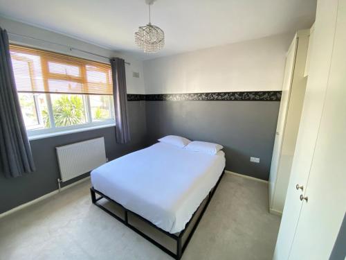 a bedroom with a white bed and a window at The Fern Two Bedroom Escape in South Norwood