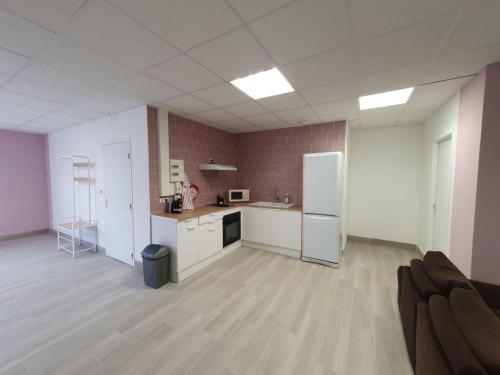 une chambre vide avec une cuisine équipée d'un réfrigérateur dans l'établissement L'arche rose, à Nailloux