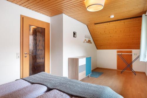 a bedroom with a bed and a wooden ceiling at Ferienwohnung Glashütte in Sankt Märgen