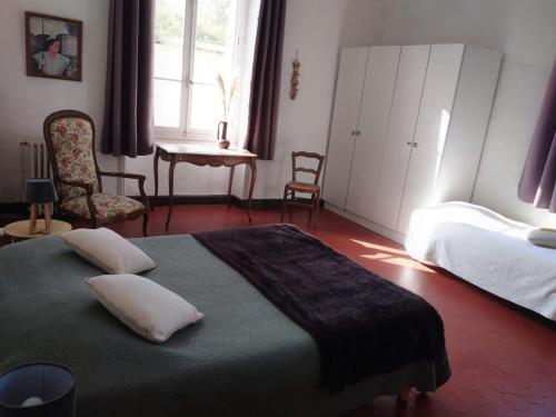 a bedroom with a bed and a table and chairs at Le Mas d'Icard in Saintes-Maries-de-la-Mer