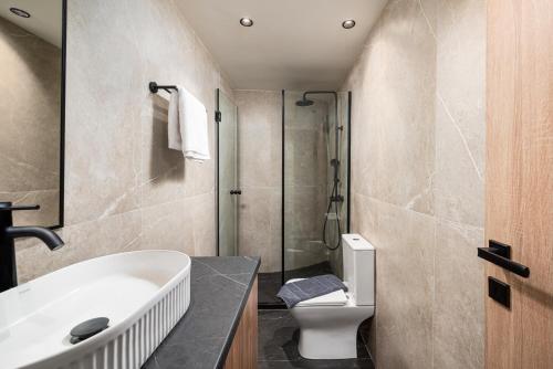 a bathroom with a sink and a toilet and a shower at Makas Beach Suites II in Hersonissos