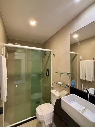 a bathroom with a shower and a toilet and a sink at Hotel Brasil Tropical in Fortaleza