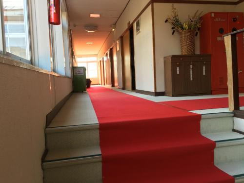 a red carpet on the stairs of a hallway at Towadako Hostel in Towada
