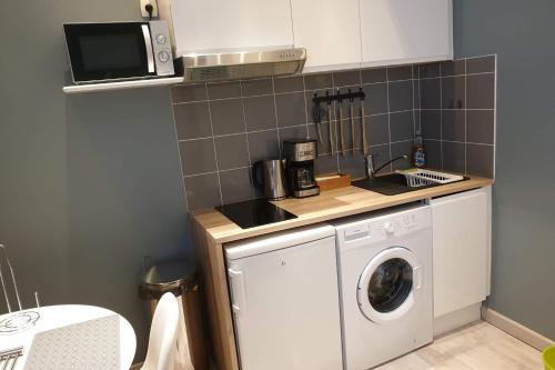 une cuisine avec un lave-linge et un micro-ondes dans l'établissement Lovely apartment in the historic center of Avignon, à Avignon