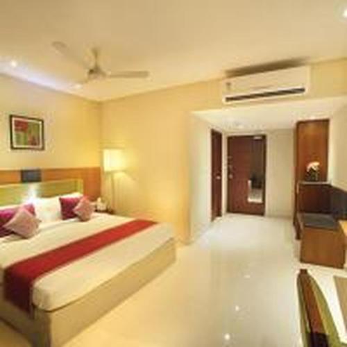 a bedroom with a large bed with a red blanket at Jk Park Residency Perambra in Mennānyam