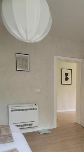 a room with a white wall with a chandelier at Casa L in Ulcinj